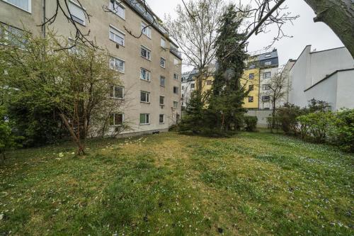 een grasveld voor sommige gebouwen bij Homely apartment - 10 minutes to Stephansplatz in Wenen