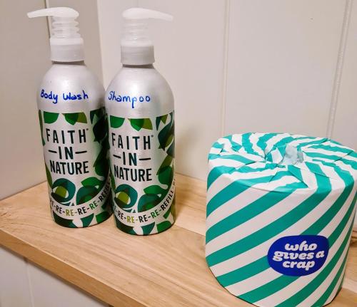 two bottles of water and a box on a wooden shelf at Milberry Green Meadows in Warlingham