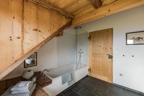 a bath tub in a bathroom with a wooden ceiling at Chalet Sophie in Longostagno