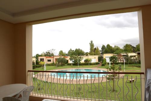 a balcony with a view of a swimming pool at Golf Royal appartement in Fès