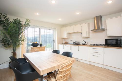 a kitchen with a wooden table and some chairs at Oceanside in Wyke Regis