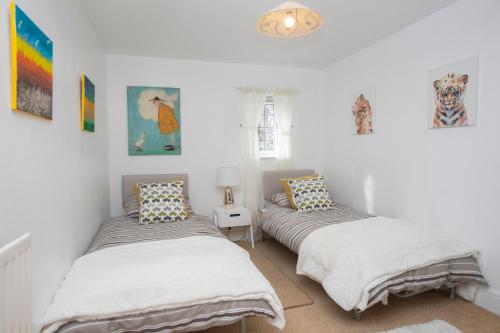two beds in a room with white walls at Oceanside in Wyke Regis