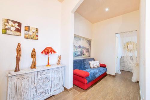 ein Wohnzimmer mit einem blauen Sofa und einem roten Stuhl in der Unterkunft Piombino Apartments - Casa Roma in Piombino