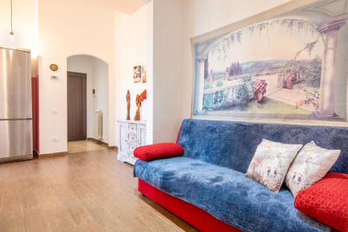 eine blaue Couch in einem Wohnzimmer mit einem Gemälde an der Wand in der Unterkunft Piombino Apartments - Casa Roma in Piombino