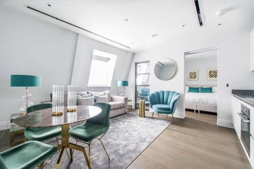 a living room with a table and green chairs at Chancery Quarters - 124 Chancery Lane in London