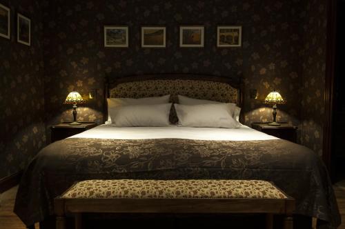 a bedroom with a large bed with two lamps at Hotel City Bell in La Plata