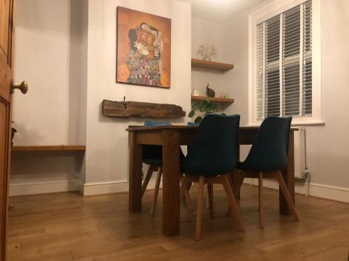 a dining room with a wooden table and chairs at Gloucester Rd 2 mins away - Fab, new, trendy house in Bristol