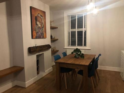 uma sala de jantar com uma mesa e uma lareira em Gloucester Rd 2 mins away - Fab, new, trendy house em Bristol