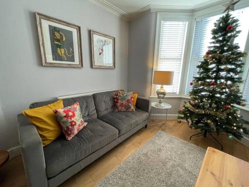 a living room with a christmas tree and a couch at Gloucester Rd 2 mins away - Fab, new, trendy house in Bristol