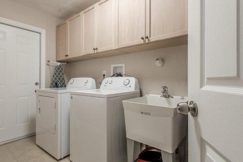 ein Badezimmer mit einem Waschbecken, einer Waschmaschine und einem Trockner in der Unterkunft Renovated Largo Heated Pool Home in Seminole