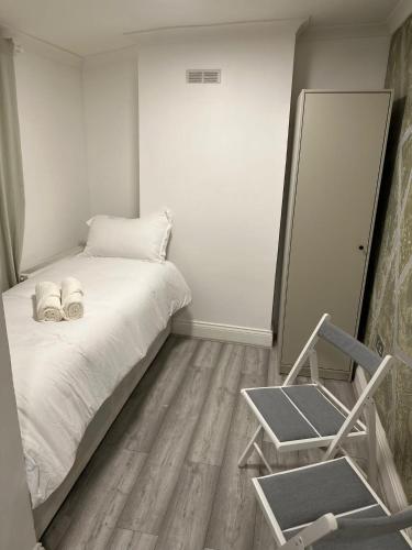 um quarto com uma cama, um espelho e uma cadeira em Single Room 9 em Londres