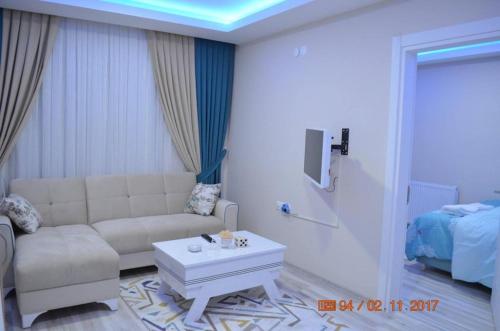 ein Wohnzimmer mit einem Sofa und einem Couchtisch in der Unterkunft Otel Sweet Home in Atakum