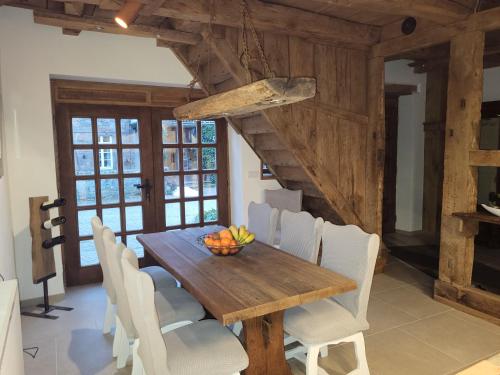 a dining room with a wooden table and white chairs at Ferienhaus Drakenhof in Bad Salzuflen
