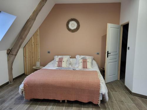 a bedroom with a bed and a clock on the wall at gite de l'écurie in Saint-Samson