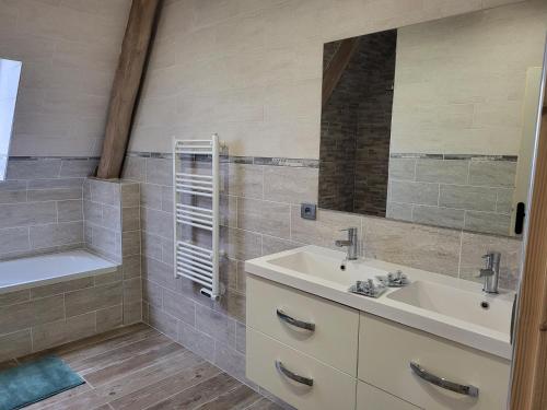 a bathroom with a sink and a tub and a mirror at gite de l'écurie in Saint-Samson