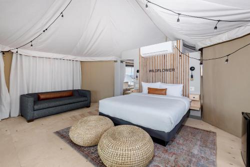 a bedroom with a bed and a couch in a tent at Zion Wildflower Resort in Virgin
