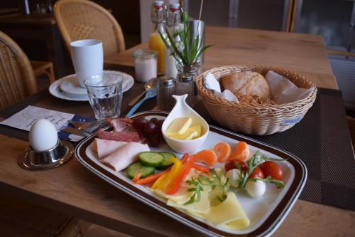 a table with a plate of food on a table at Pension Zum Alten Fährhaus in Rostock