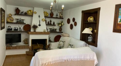 Casa rural La Matriche في ميخاس: غرفة معيشة مع سرير ومدفأة