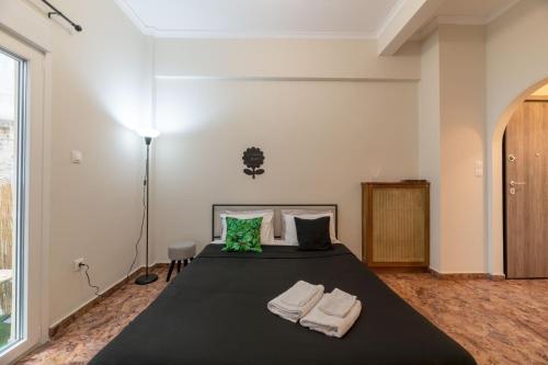 - une chambre avec un grand lit noir et des serviettes dans l'établissement Pink Flat Exarcheia Athens Netflix, à Athènes