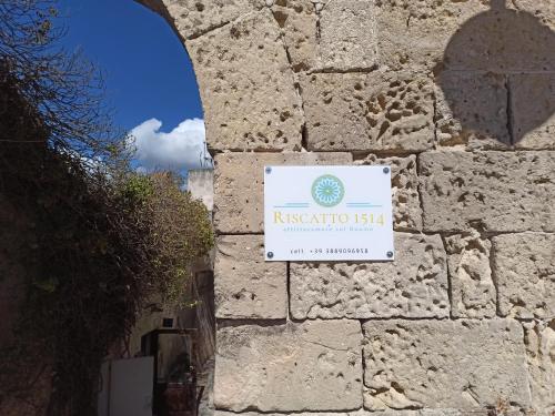a sign on the side of a stone wall at Riscatto 1514 in Matera
