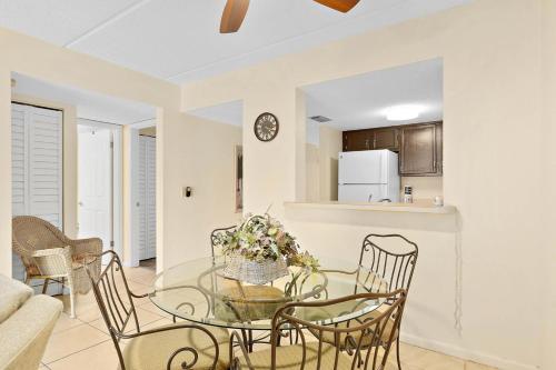 a dining room and living room with a glass table and chairs at Unit 2105 - Ocean & Racquet Resort in Saint Augustine Beach