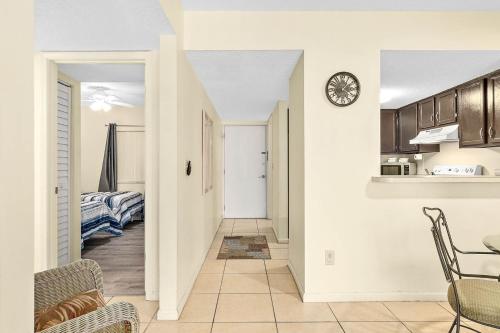 a kitchen with a table and a clock on a wall at Unit 2105 - Ocean & Racquet Resort in Saint Augustine Beach