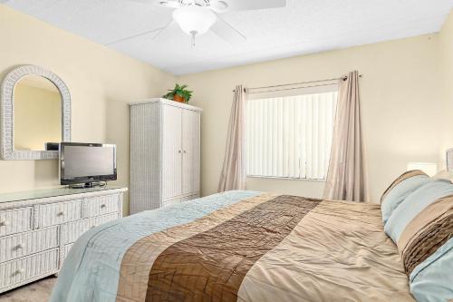a bedroom with a bed and a tv on a dresser at Unit 2105 - Ocean & Racquet Resort in Saint Augustine Beach