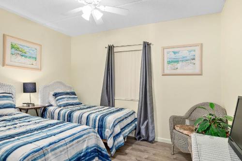 a bedroom with two beds and a ceiling fan at Unit 2105 - Ocean & Racquet Resort in Saint Augustine Beach