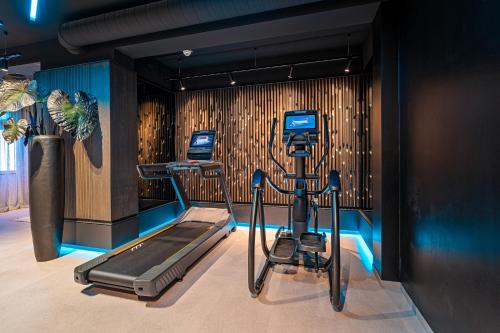 a room with a gym with a treadmill and exercise equipment at Hotel Riedenburg in Bad Füssing