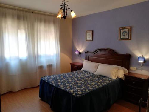 1 dormitorio con 1 cama y una ventana con cortinas en Complejo rural Mirador del Condado, en Castellar de Santisteban