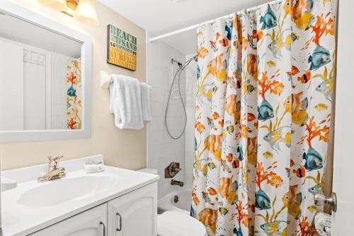 ein Badezimmer mit einem Duschvorhang, einem WC und einem Waschbecken in der Unterkunft Unit 5211 - Ocean Racquet Resort in Saint Augustine Beach
