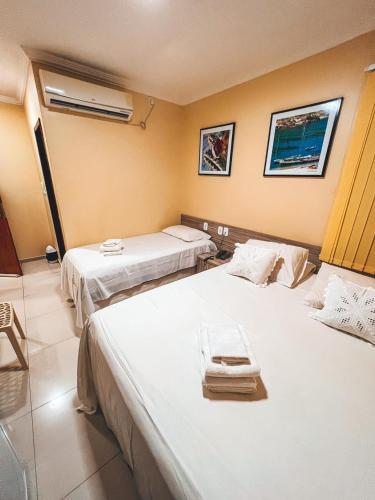 a hotel room with two beds with white sheets at Pousada do imperador in Piranhas