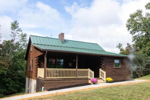 a log cabin with a green roof at Maple Leaf Cabin in Millersburg