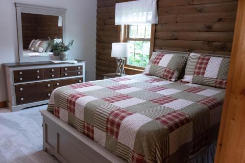 a bedroom with a bed and a dresser and a mirror at Maple Leaf Cabin in Millersburg