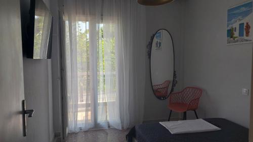 1 dormitorio con tabla de surf, cama y ventana en LENIA, en Nea Plagia