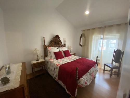 a bedroom with a large bed with red pillows at Casa dos Telhados 