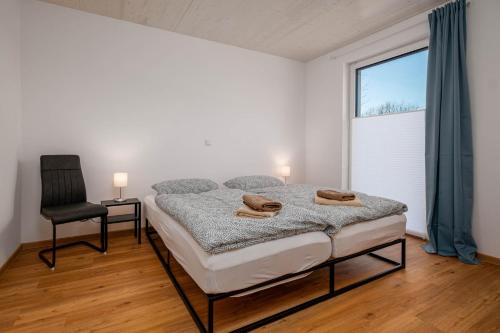 a bedroom with a bed and a chair and a window at Am Thie in Hoisdorf