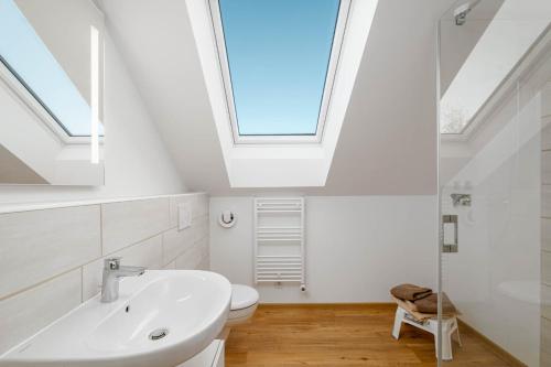 een badkamer met een wastafel en een dakraam bij Am Thie in Hoisdorf