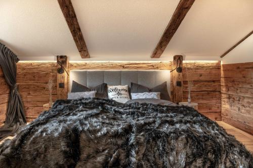 a bedroom with a large bed with wooden walls at Chalet Laugenblick in Santa Valburga St. Walburg