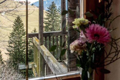a vase of flowers sitting next to a window at Chalet Laugenblick in Santa Valburga St. Walburg