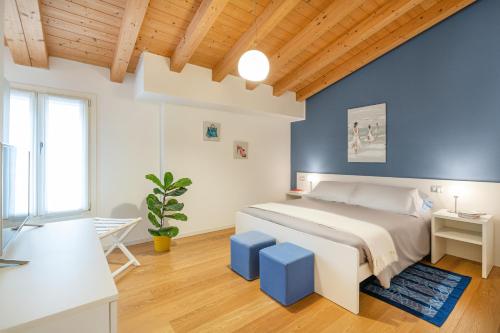 um quarto com uma cama e uma parede azul em Ca' Degli Antichi Giardini Apartments em Veneza