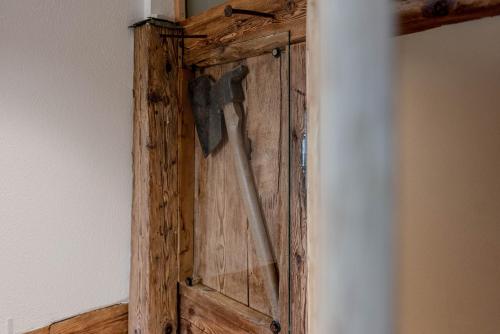 a wooden door with a hammer on a wall at Chalet Laugenblick in Santa Valburga St. Walburg