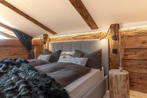 a bed in a room with wooden walls at Chalet Laugenblick in Santa Valburga St. Walburg