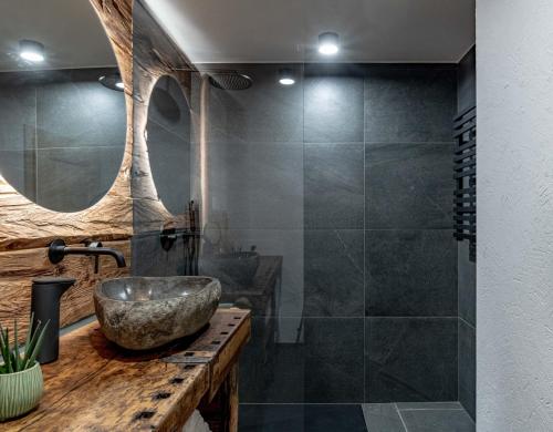 a bathroom with a stone sink and a shower at Chalet Laugenblick in Santa Valburga St. Walburg