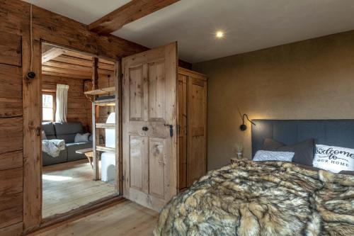 a bedroom with a bed and wooden walls at Chalet Laugenblick in Santa Valburga St. Walburg