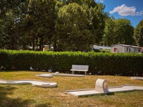 a park with a bench and amphitheater in the grass at location mobil-home le parc des roches in Saint-Chéron