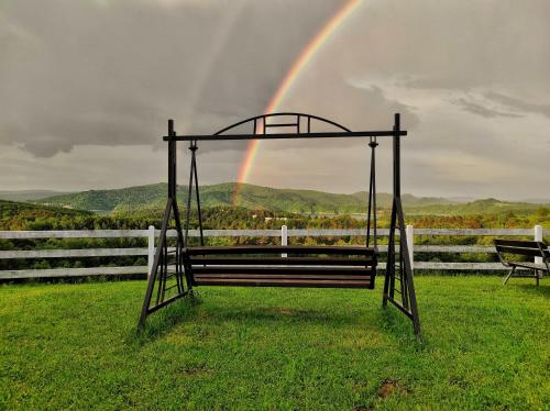 a swing with a rainbow in the background at Noclegi Rezydent Polańczyk in Polańczyk