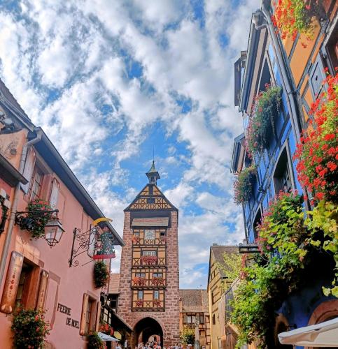 a clock tower in the middle of a street at Un balcon sur les toits in Beblenheim