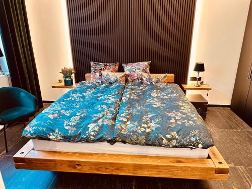 a bedroom with a bed with a blue comforter at holidayAHRpartment in Bad Neuenahr-Ahrweiler