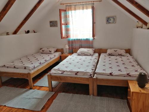 two beds in a room with a window at Country House Na Malenom brijegu in Bjelovar